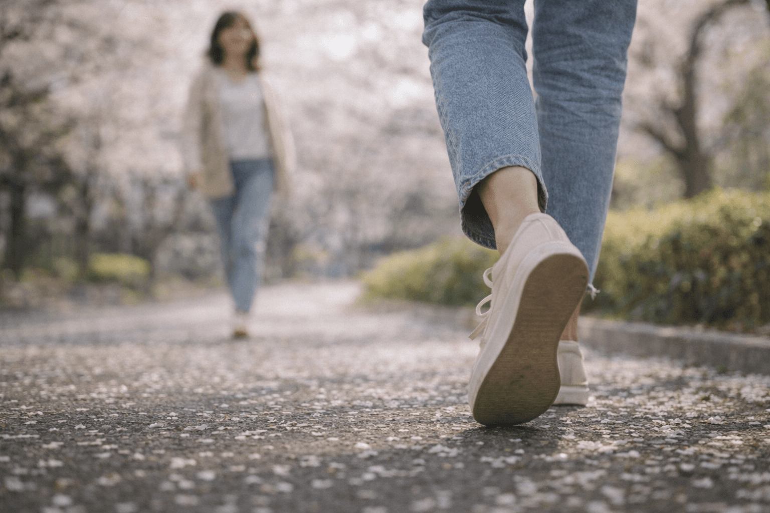 桜の道を歩き出す女性──一歩踏み出す勇気