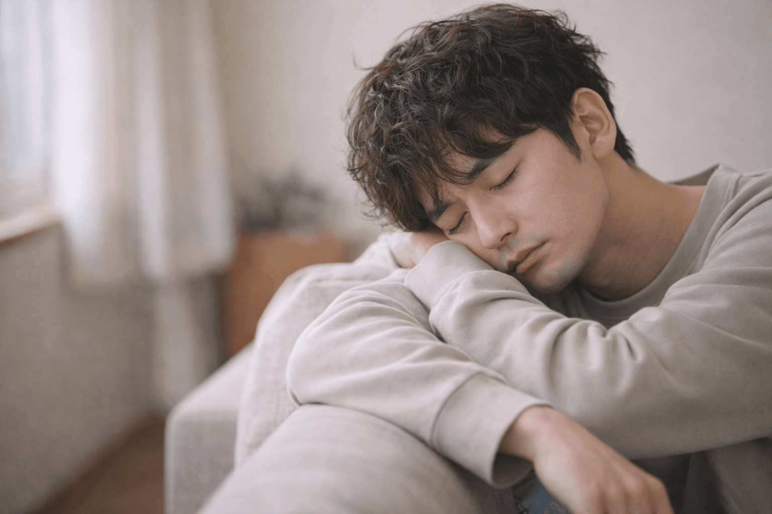 疲れてソファで眠る男性──バッテリー切れの沈黙